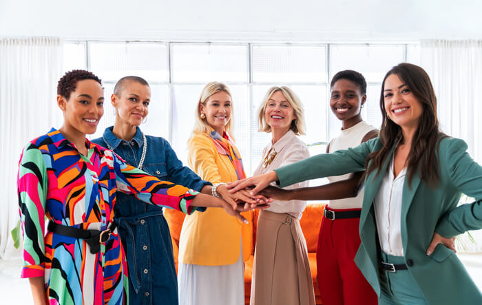 6 women sticking their hands in a circle